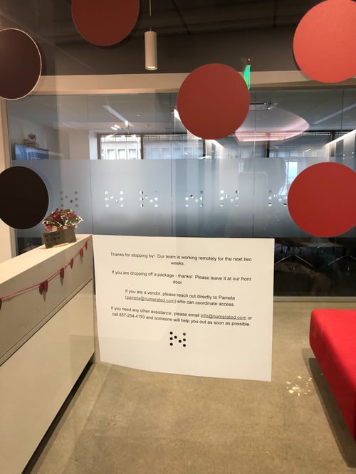 A sign hangs in the front door of Numerated's Headquarters, alerting visitors that the company will be working from home during the Covid-19 Pandemic.